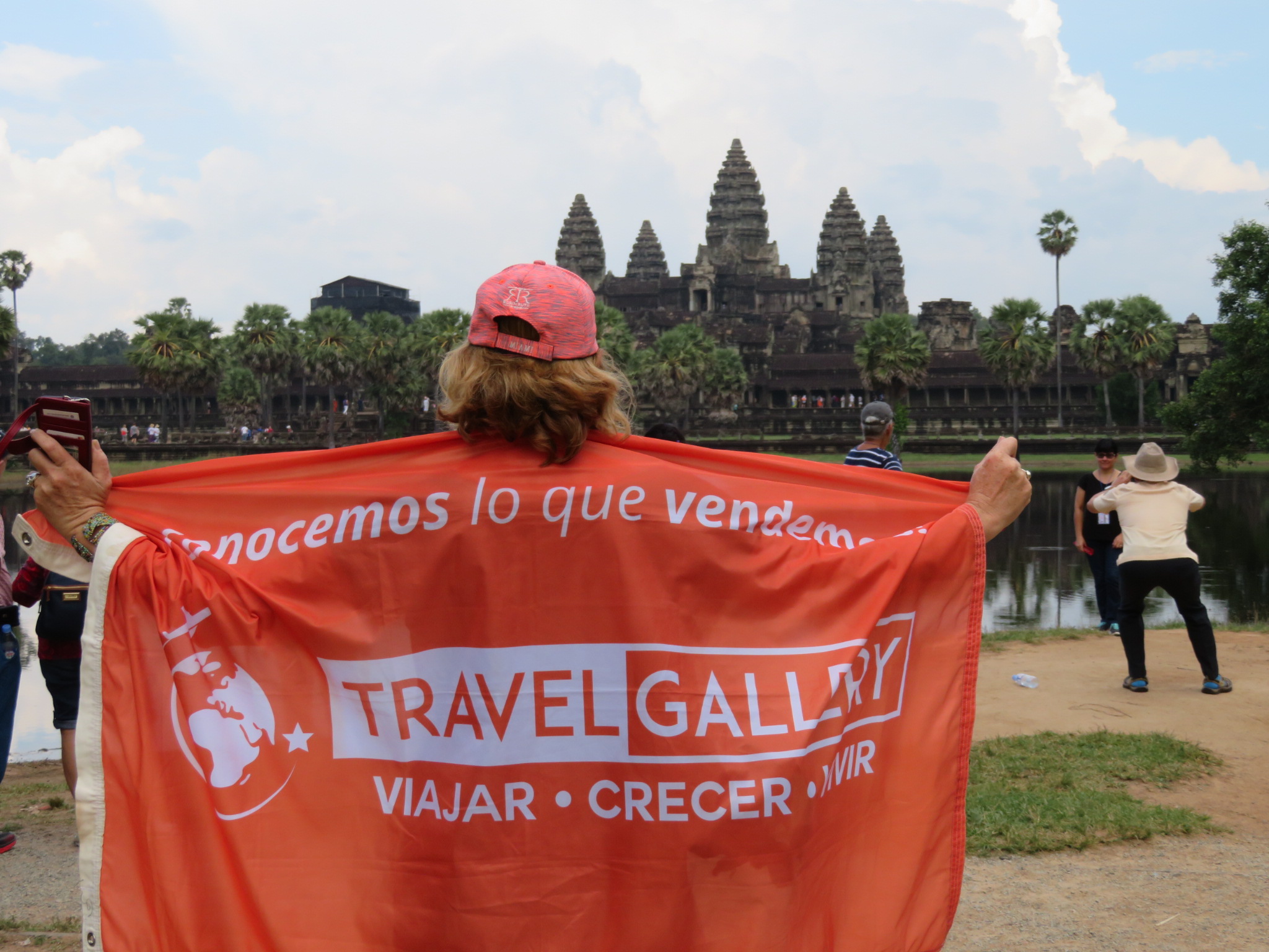 Presidenta de travel gallery de espalda aguantando la bandera con el logo de su companía